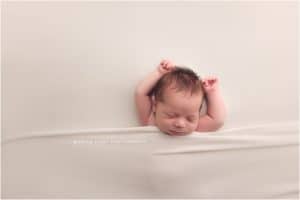 Baby boy newborn photography session in Bentonville Arkansas | baby on cream background unposed