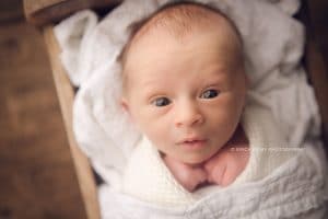 Newborn Photographers NWA | baby boy photo session, wide awake in white quilt and knit wrap | Erica Kirby Photography