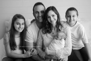 Newborn Photographers NWA | Newborn baby boy photo session in Rogers AR baby with family on white bed | Erica Kirby Photography