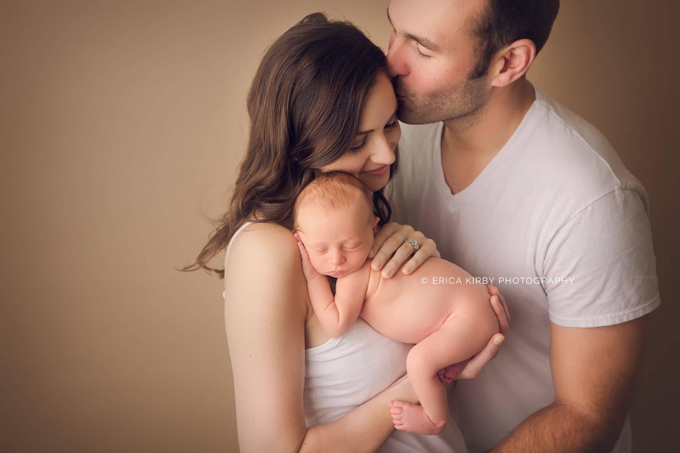 Newborn Photographers NWA | Newborn baby boy photo session in Rogers AR baby with mom and dad giving kisses | Erica Kirby Photography 