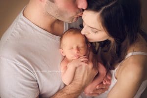 Newborn Photographers NWA | Newborn baby boy photo session in Rogers AR baby with mom and dad giving kisses | Erica Kirby Photography