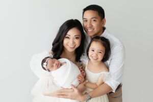 Bentonville Arkansas Newborn Photography Session baby girl with family in all white light and airy studio photos